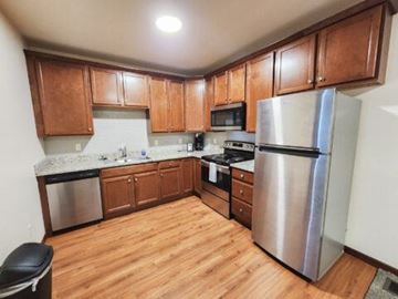 Rapid City apartment for rent - A kitchen with wooden cabinets and a stainless steel refrigerator.