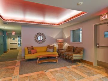 Portland apartment for rent - A living room with a yellow couch and a clock on the wall.