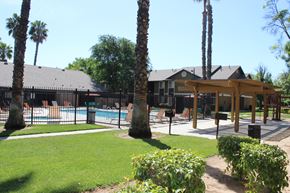 Perris apartment for rent - A pool surrounded by a fence and trees.