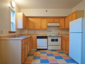 Portland apartment for rent - A kitchen with wooden cabinets and a checkered floor.