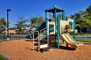 Brentwood apartment for rent - A playground with a green slide and a blue roof.