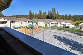 Grass Valley apartment for rent - A playground with a swing set and a basketball court in a residential area.