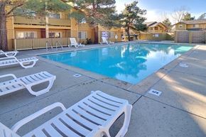 Oroville apartment for rent - A pool surrounded by white lounge chairs.