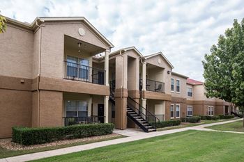 Apartment complex with a green lawn in front.