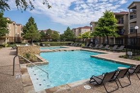 Mesquite apartment for rent - A swimming pool surrounded by chairs and trees at Infinity on Sunnyvale Apartments , Mesquite, 75150
