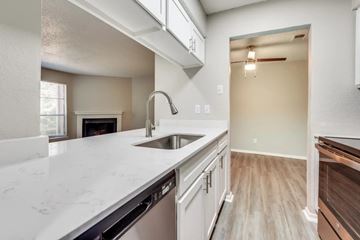 Dallas apartment for rent - A kitchen with a white counter top and a stainless steel dishwasher.