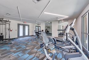 Dallas apartment for rent - A gym with a treadmill, elliptical machines, and other exercise equipment at Infinity on the Oaks Apartments, Dallas