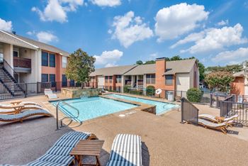 A sunny day at a poolside with lounge chairs and a clear blue sky.