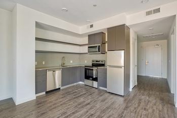 A kitchen with a refrigerator, oven, and microwave.