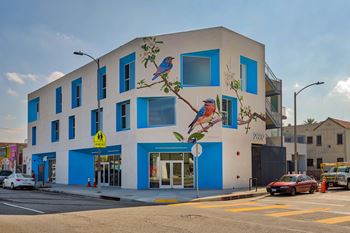 A blue and white building with a mural of a bird on it.