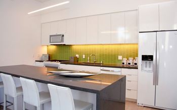 A modern kitchen with white cabinets and a black countertop.