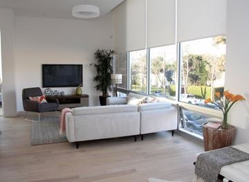 Los Angeles apartment for rent - A living room with a grey sofa and a television on the wall.