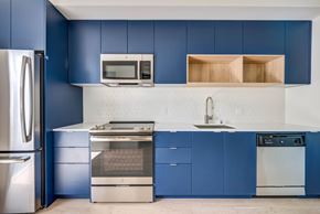 Los Angeles apartment for rent - A kitchen with blue cabinets and a stainless steel refrigerator.at Junction 4121, California