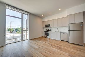 Los Angeles apartment for rent - A kitchen with white cabinets and a wooden floor.at 5135 W Adams, Los Angeles California