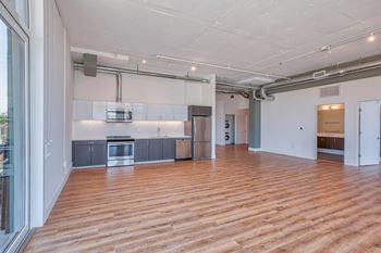 A kitchen area with wooden floors and a white ceiling.