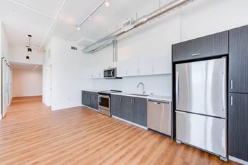 A kitchen with wooden floors and stainless steel appliances.