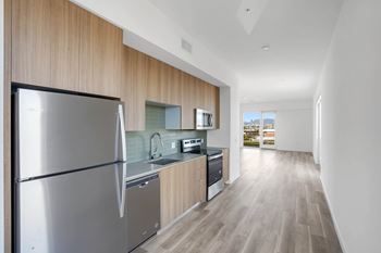 A modern kitchen with a refrigerator, sink, and stove.