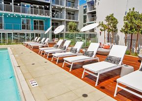 Los Angeles apartment for rent - A pool with sun loungers and a building in the background at Prizma in Los Angeles, CA, 90038