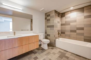 A bathroom with a white tub, sink, and toilet.