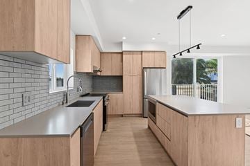 Los Angeles apartment for rent - A modern kitchen with wooden cabinets and a grey countertop.