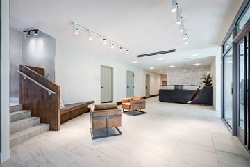 Washington apartment for rent - A modern interior space with a staircase, seating area, and glass doors.