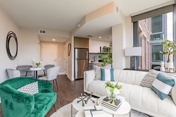 Washington apartment for rent - A living room with a green chair and a white couch.