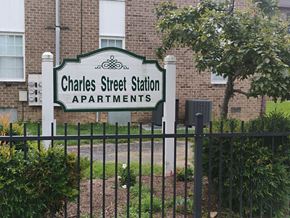 Strasburg apartment for rent - A sign for Charles Street Station Apartments stands in front of a brick building.