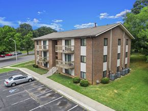 Roanoke apartment for rent - A car is parked in a parking lot in front of a brick apartment building.