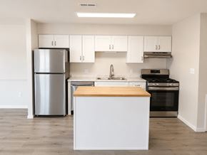 Manassas apartment for rent - A kitchen with white cabinets and a wooden island.