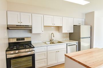 Manassas apartment for rent - A kitchen with white cabinets and a wooden counter top.