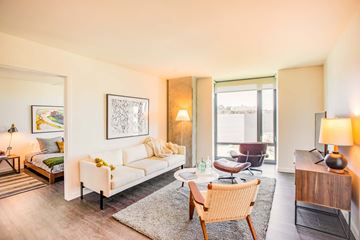 San Francisco apartment for rent - A well-lit, modern living room with a white sofa and a wooden chair.