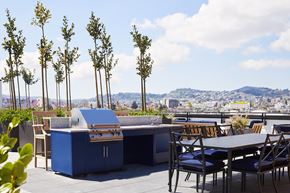 San Francisco apartment for rent - A blue outdoor kitchen with a grill and a table with chairs.