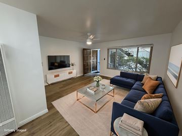 Santa Monica apartment for rent - A living room with a blue couch and a glass coffee table.