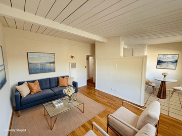 Los Angeles apartment for rent - A living room with a blue couch, a glass coffee table, and a painting on the wall.