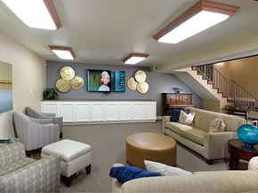 Huntington Beach apartment for rent - A living room with a striped chair, a couch, and a blue ottoman.