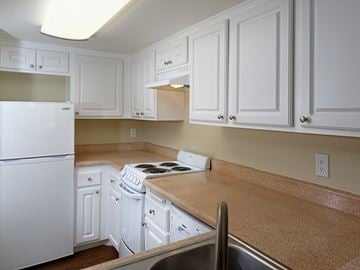 Huntington Beach apartment for rent - A kitchen with white cabinets and a white fridge.