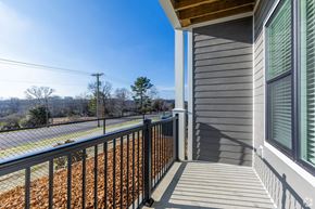 Brentwood apartment for rent - A balcony with a metal railing and a view of a hill with trees.