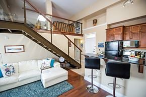 Halifax apartment for rent - A living room with a staircase and a kitchen area.