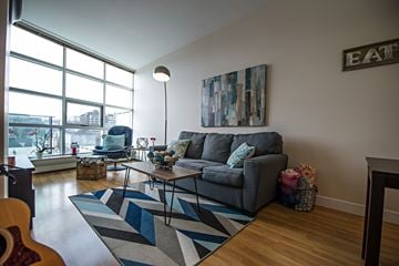 Halifax apartment for rent - A living room with a grey couch and a guitar on the floor.