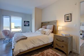 Halifax apartment for rent - A bedroom with a large bed and a chair by the window.