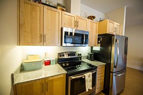 Dartmouth apartment for rent - A kitchen with wooden cabinets and a black stove top oven.