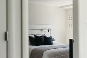 Halifax apartment for rent - A bedroom with a bed and a wall-mounted shelf with pictures.