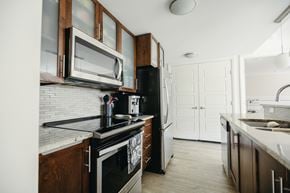 Halifax apartment for rent - A kitchen with white cabinets and a black stove top oven.