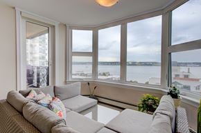 Halifax apartment for rent - A living room with a couch and a view of the water.