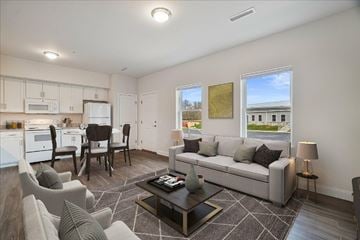 Dover apartment for rent - A well-lit living room with a grey sofa and a coffee table.