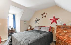 Wrightsville apartment for rent - A bedroom with a bed, dresser, and three star decorations on the wall.