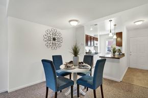 York apartment for rent - A dining room with a table set for two and a decorative wall hanging.