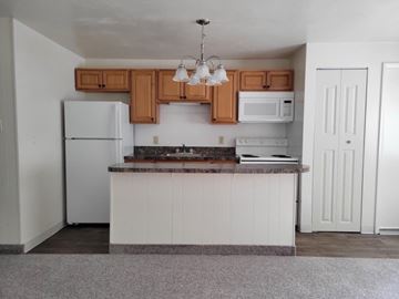 Mount Wolf apartment for rent - A kitchen with white cabinets and a white fridge.