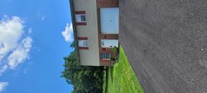 York apartment for rent - A building with a grey wall and a blue sky with clouds.