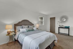 Indiana apartment for rent - A bedroom with a large bed and a mirror on the wall.